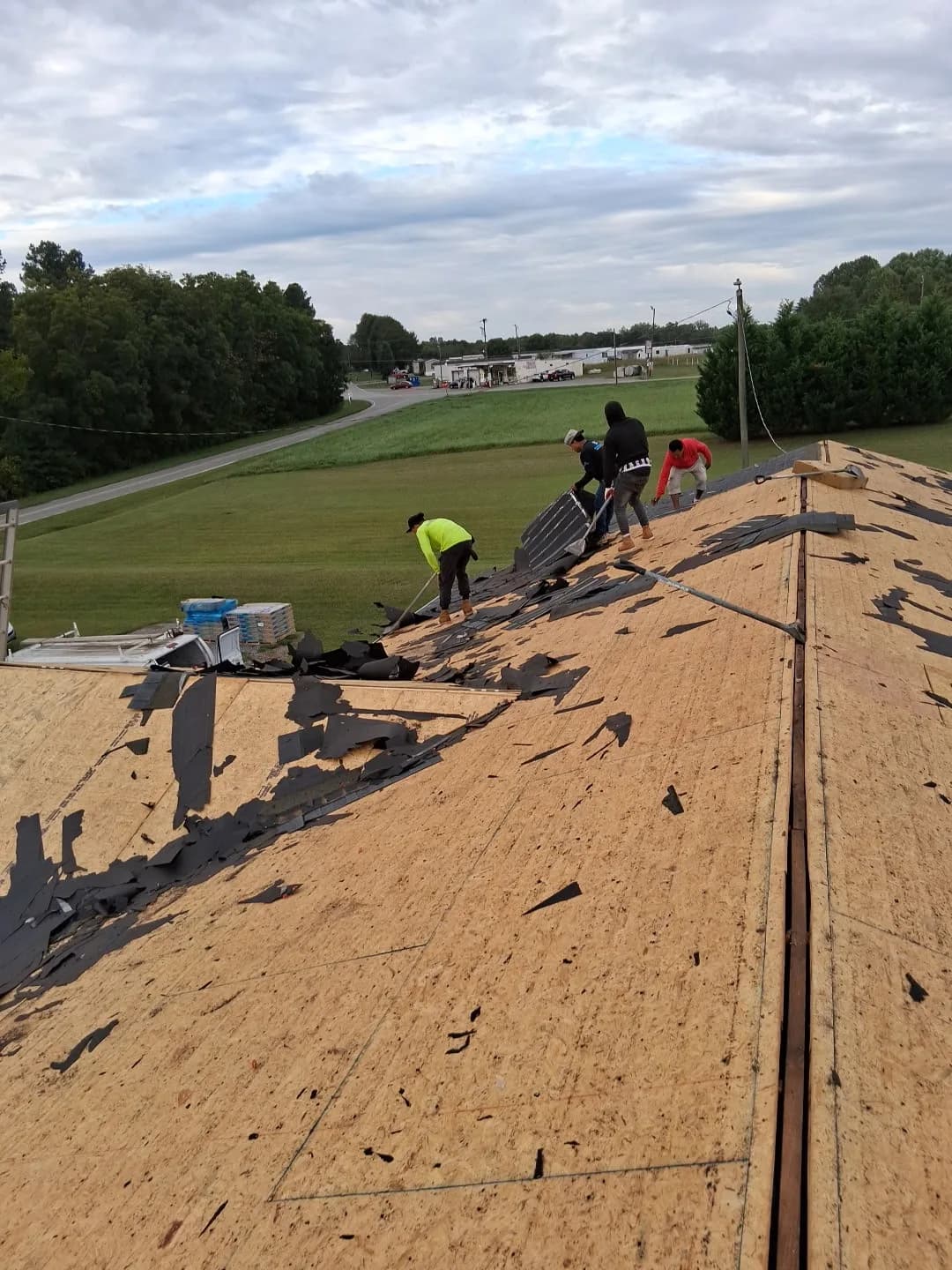 Sage Roofing Solutions crew removing old shingles during a roof replacement
